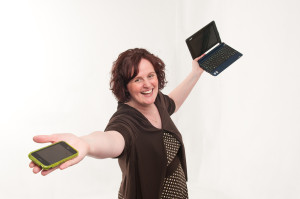 Angela Crocker holding an iPhone and laptop